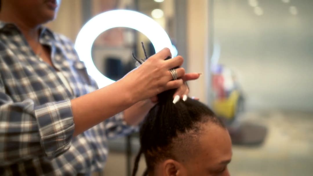 JB at work on a client's locs